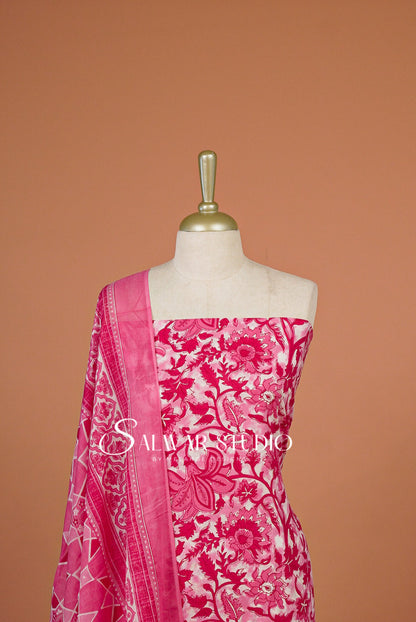 A pink and white printed cotton fabric set with a matching sheer dupatta draped over a mannequin torso.