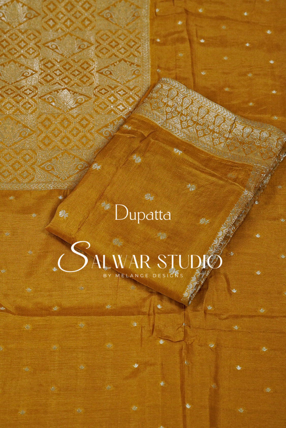 A mustard yellow salwar suit fabric  featuring a printed dupatta with a geometric pattern and a matching printed kurta fabric with small silver motifs.