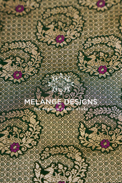 A close-up of a woven Banarasi Silk Brocade Banarasi Silk Brocade Fabric with an ornate damask pattern in olive green, gold, and deep purple.
