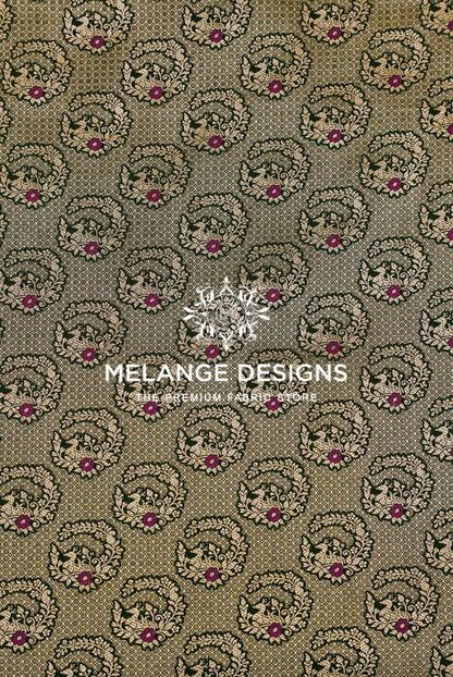 A close-up of a Banarasi Silk Brocade Banarasi Silk Brocade Fabric pattern featuring a repeating circular floral and paisley motif in olive green, beige, and magenta.