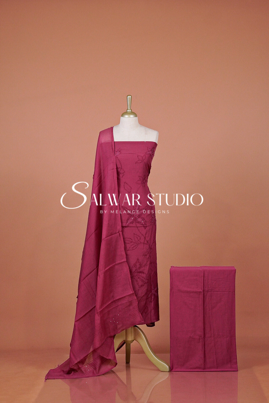 A magenta pink fabric drape and matching folded cloth .