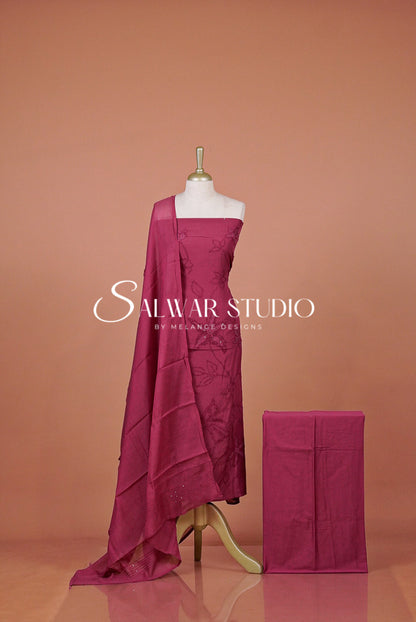 A magenta pink fabric drape and matching folded cloth .