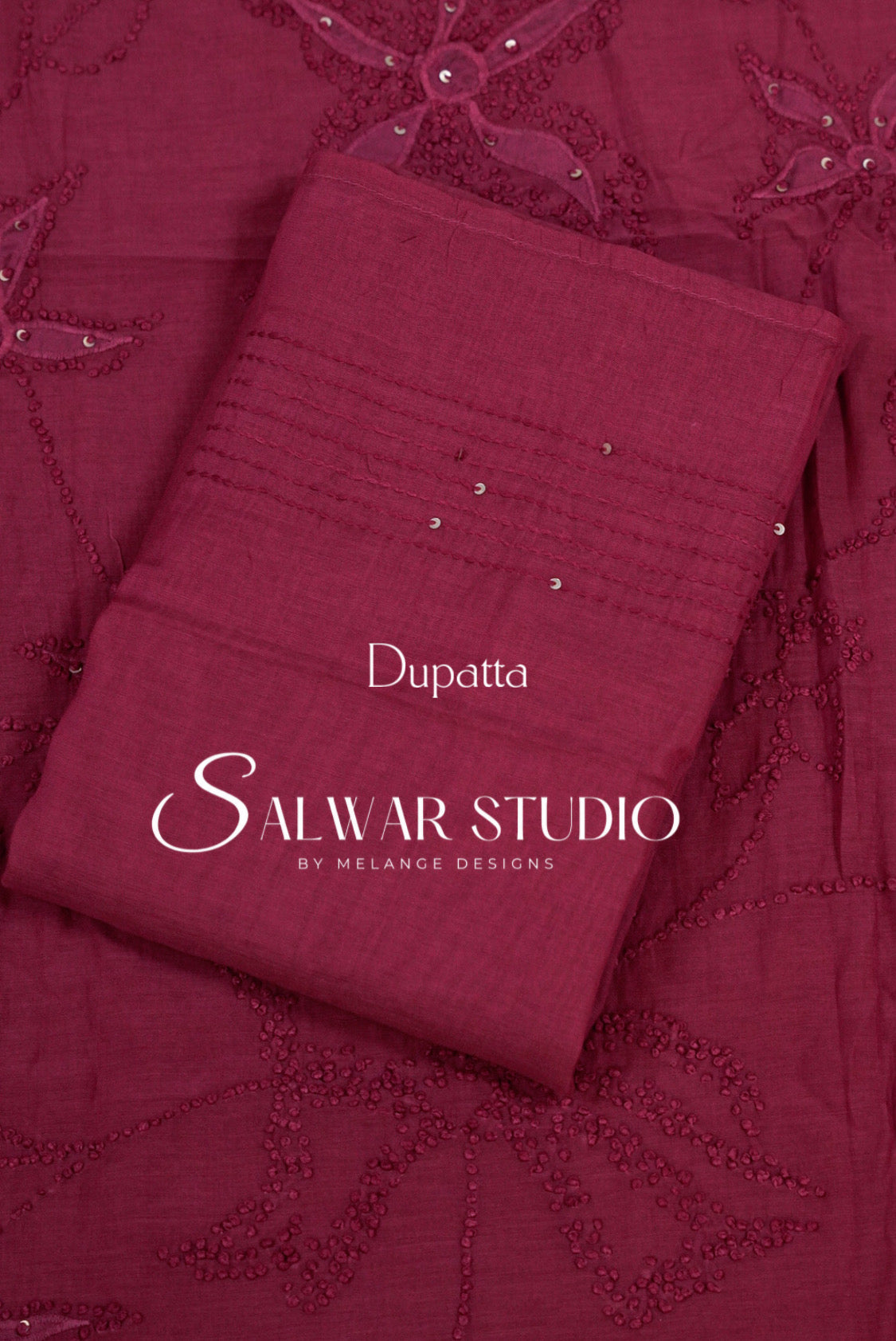 A folded maroon dupatta with embroidered floral patterns and small silver embellishments, matching embroidered fabric . 