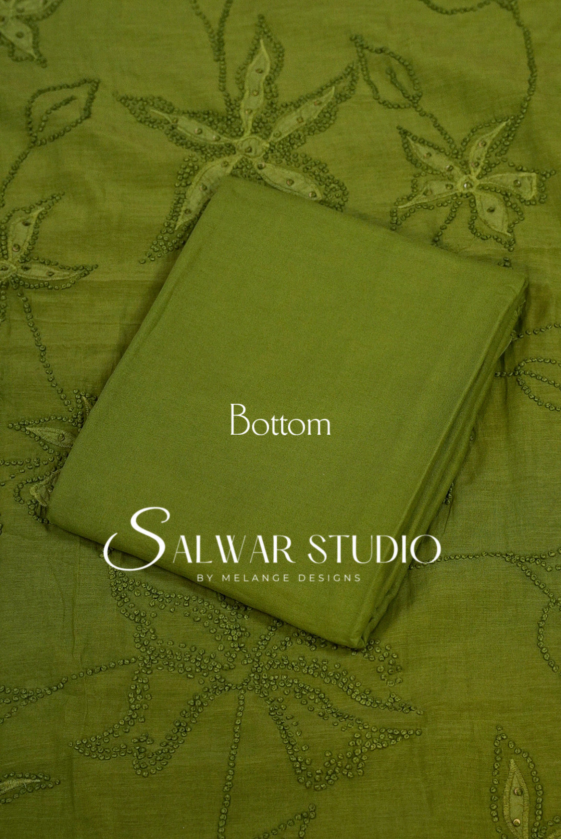 An olive green folded fabric piece labeled Bottom .placed on a matching embroidered fabric.