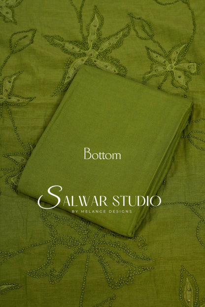 An olive green folded fabric piece labeled Bottom .placed on a matching embroidered fabric.