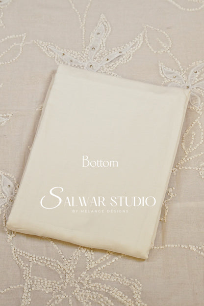 A folded cream-colored fabric garment or textile piece with printed text reading Bottom.