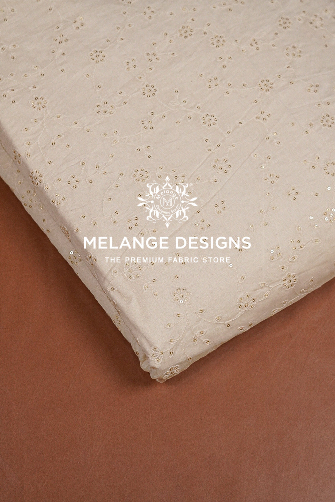 A close-up of a cream-colored Chanderi Silk Embroidery Fabric with a delicate gold floral pattern.