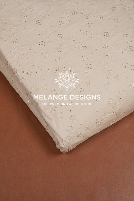 A close-up of a cream-colored Chanderi Silk Embroidery Fabric with a delicate gold floral pattern.