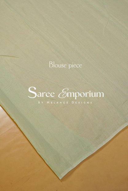 A delicate Kota Embroidery Saree in a refreshing pastel mint-green shade, beautifully detailed with intricate floral embroidery throughout. The sheer, lightweight texture gives it an airy and graceful drape, while the scalloped embroidered border adds a refined feminine finish.