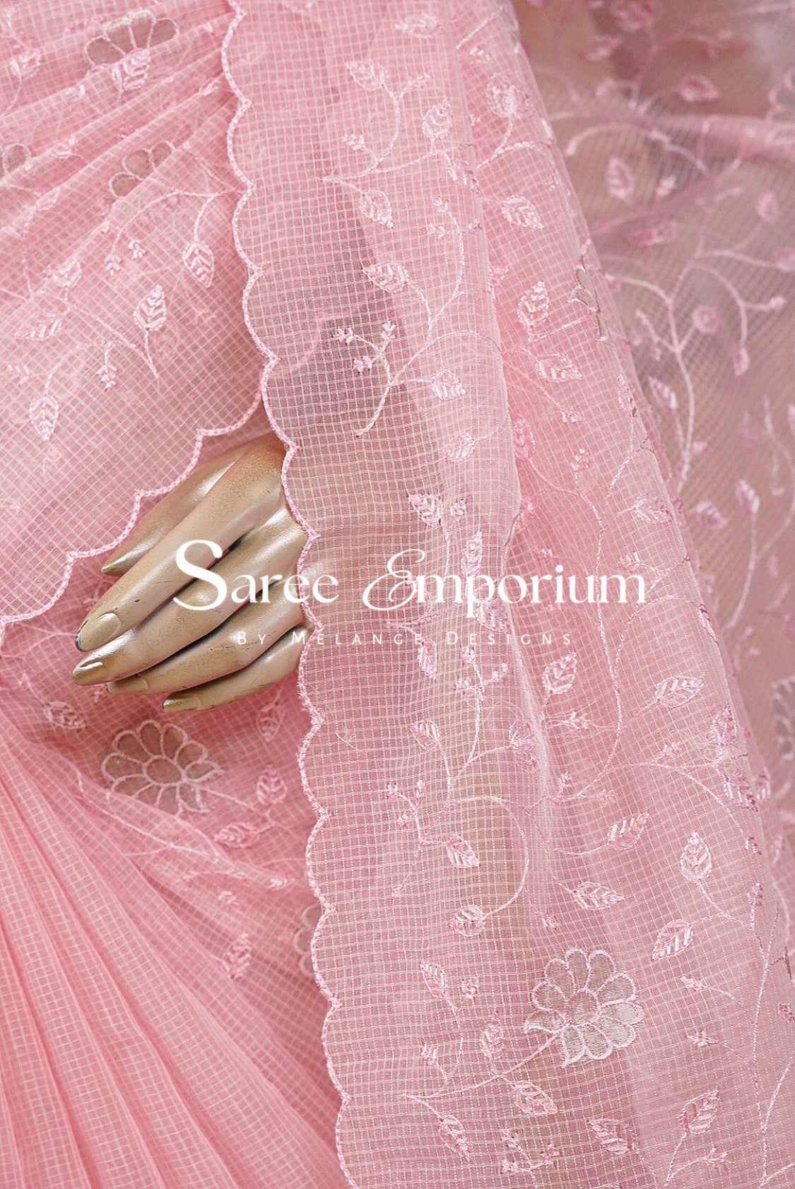 Pink floral embroidered tulle fabric with a scalloped lace border.