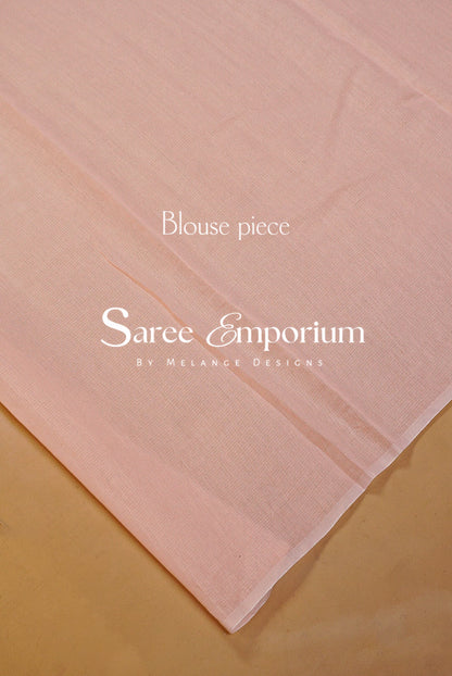 A pale blush pink sheer fabric blouse piece laid diagonally on a warm beige surface.