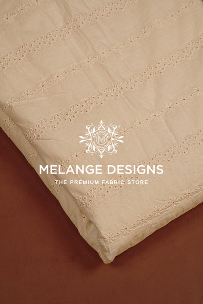 A close-up of a cream-colored Cotton Hacoba Fabric Dyeable with delicate eyelet embroidery.