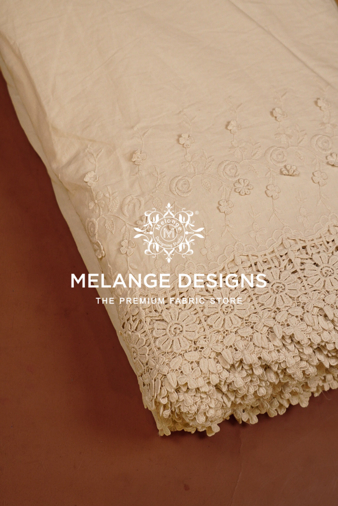 A close-up of a cream-colored Cotton Plazzo Fabric Dyeable with intricate floral embroidery and a decorative lace border.