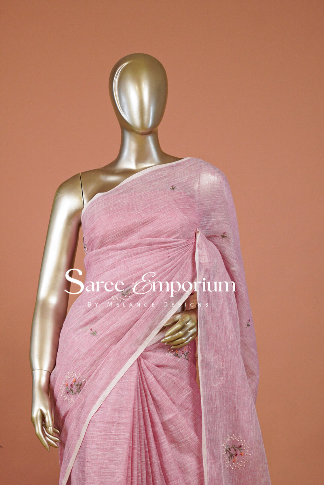 A pink saree with small floral embroidery and a white border.