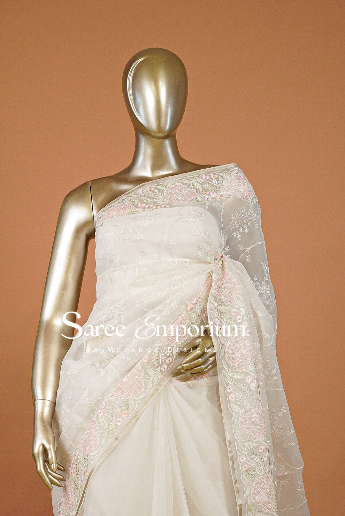 A white and pink embroidered saree .
