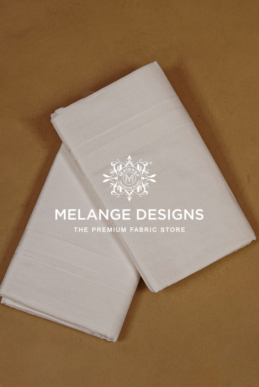 Two folded white fabric dhotis.
