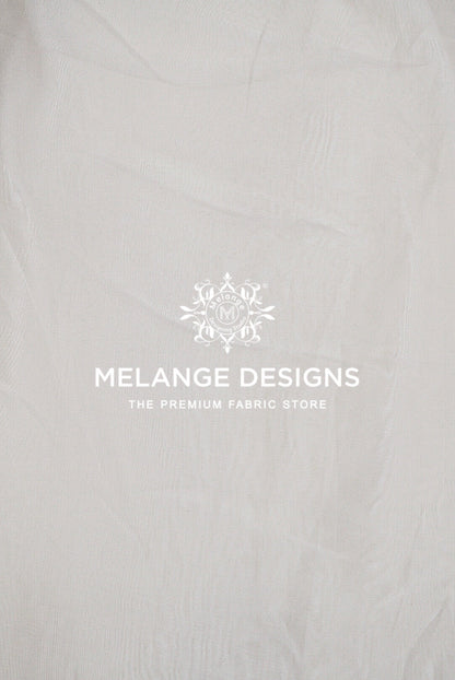A close-up of a light gray or off-white textured Premium Viscose Organza Fabric Dyeable .