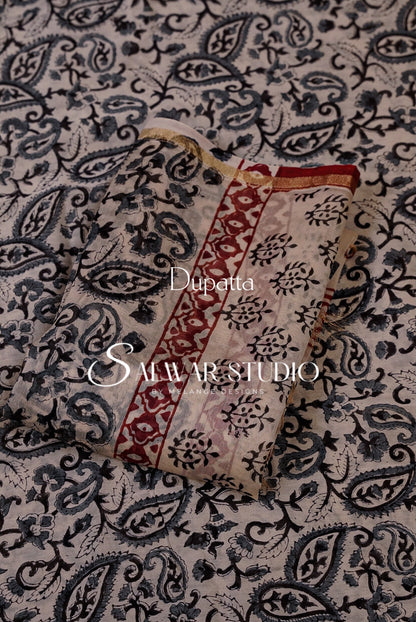 A dupatta fabric sample with a beige base and intricate navy blue paisley pattern, featuring a red and navy floral border.