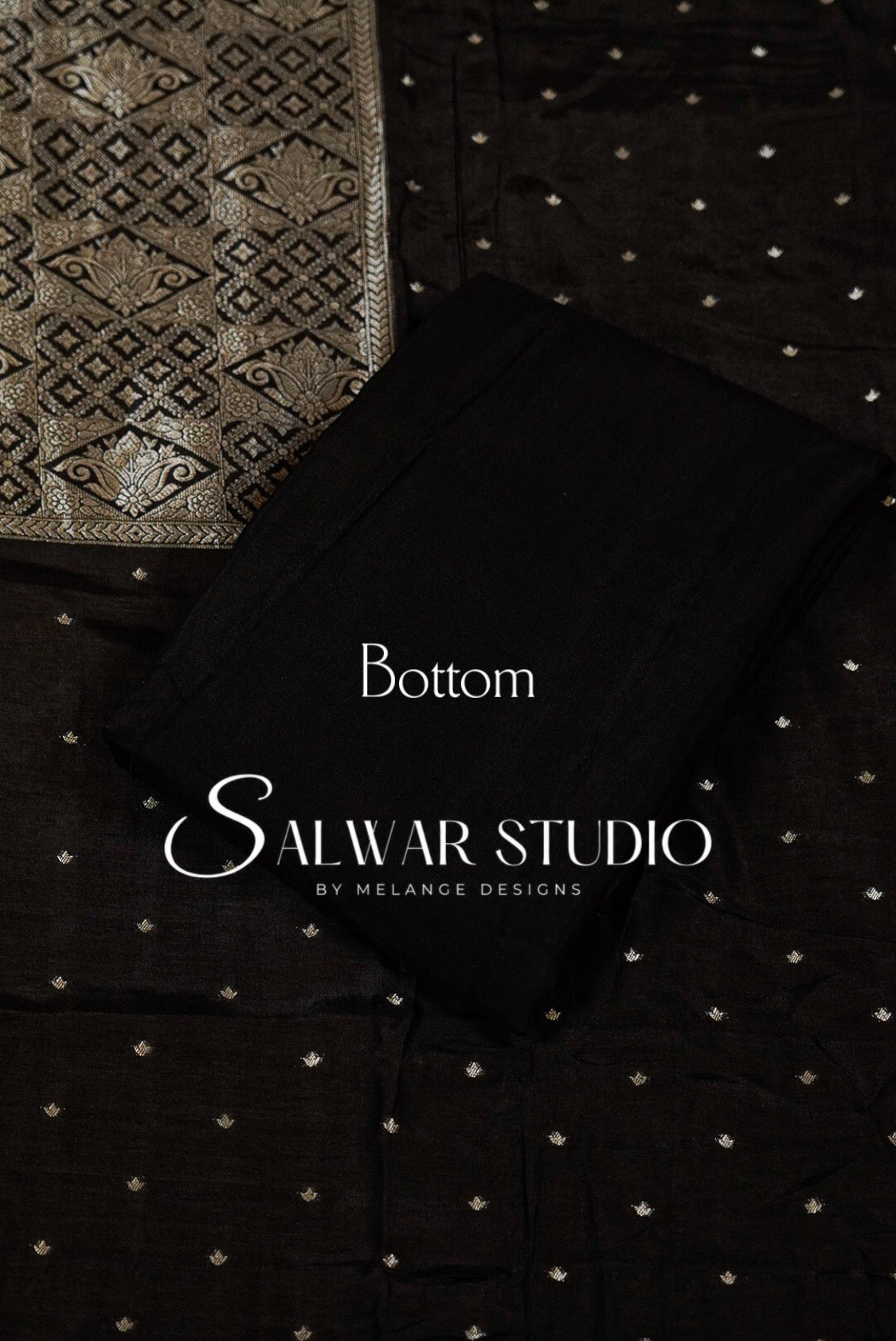 Black salwar kameez bottom fabric with small gold motifs, shown folded over a matching patterned black and gold fabric.