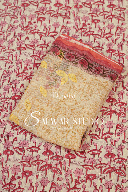 A folded beige printed fabric piece with pink and red floral motifs and a patterned border.