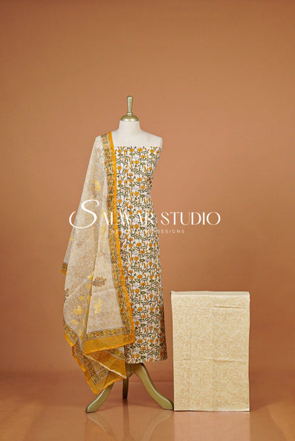 A traditional salwar suit set displayed  featuring a printed salwar, a matching kurta, and a sheer printed dupatta.