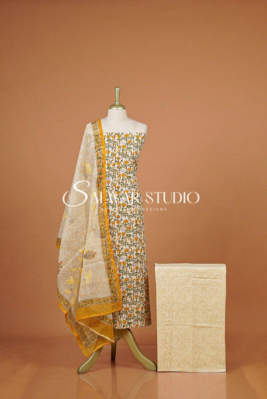 A traditional salwar suit set displayed  featuring a printed salwar, a matching kurta, and a sheer printed dupatta.