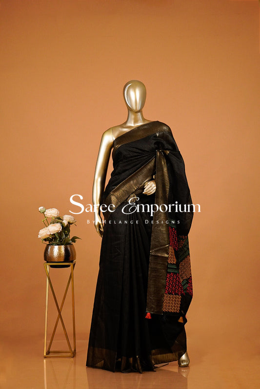 A black saree with a gold border and a multicolor patterned pallu .