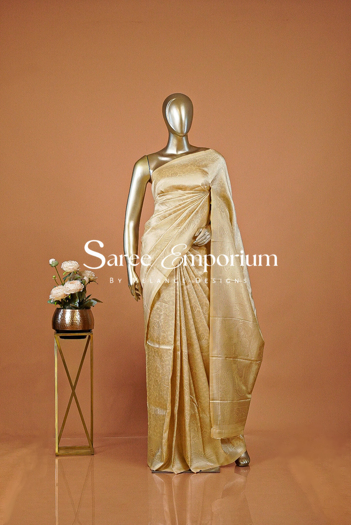A timeless Semi Silk Saree in a rich champagne-gold shade, featuring an elegant all-over jacquard weave with intricate traditional motifs. The subtle sheen enhances its luxurious appeal, while the finely woven border and detailed pallu add depth and sophistication to the overall look.