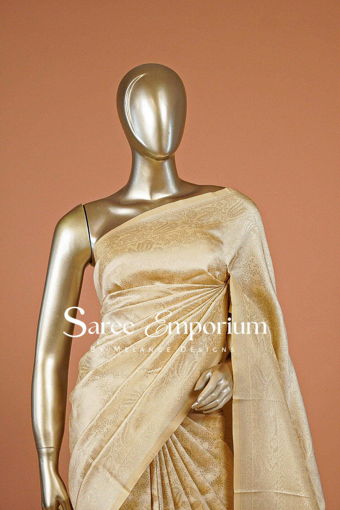 A timeless Semi Silk Saree in a rich champagne-gold shade, featuring an elegant all-over jacquard weave with intricate traditional motifs. The subtle sheen enhances its luxurious appeal, while the finely woven border and detailed pallu add depth and sophistication to the overall look.