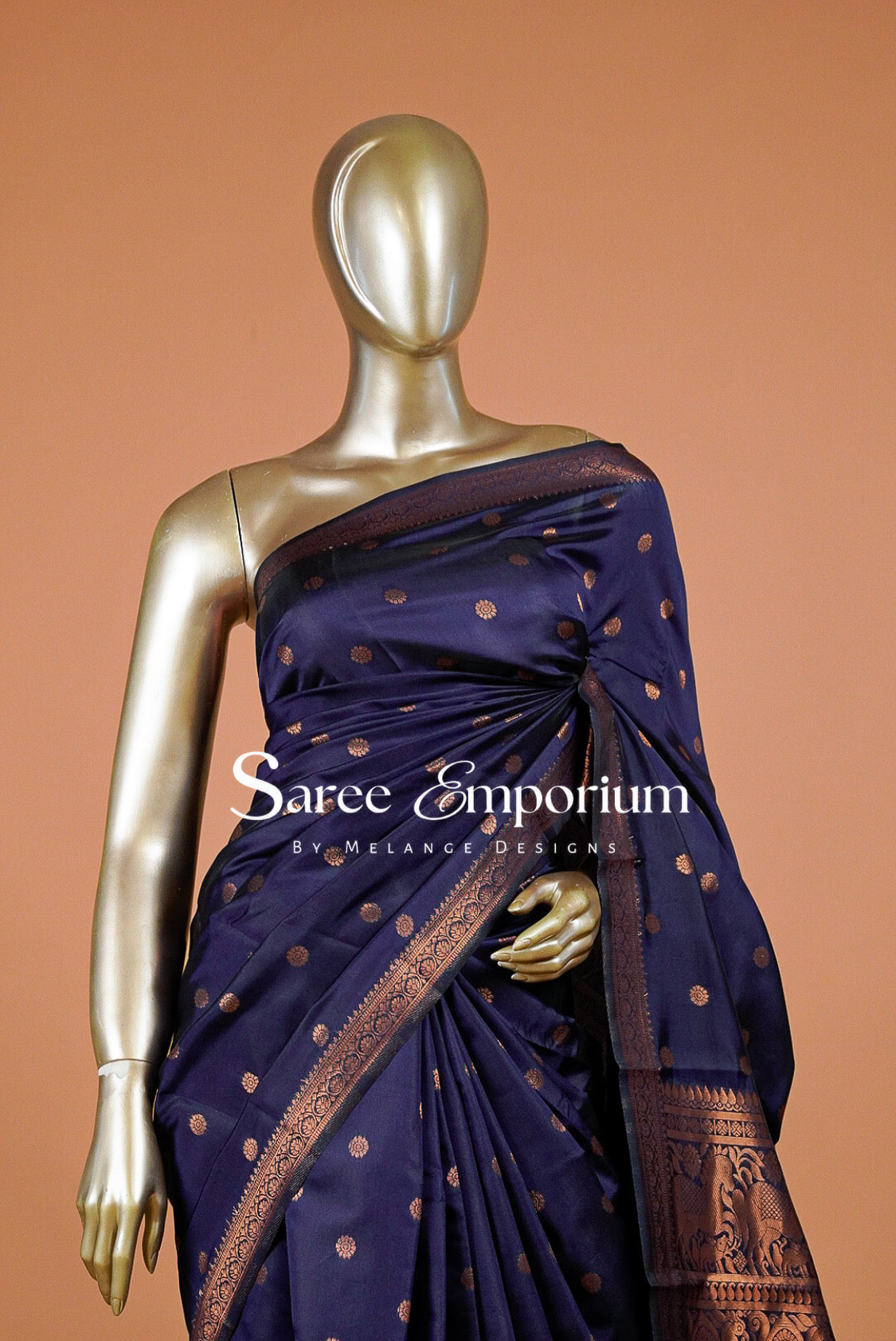 A dark navy blue silk saree with metallic bronze-gold motifs and borders.