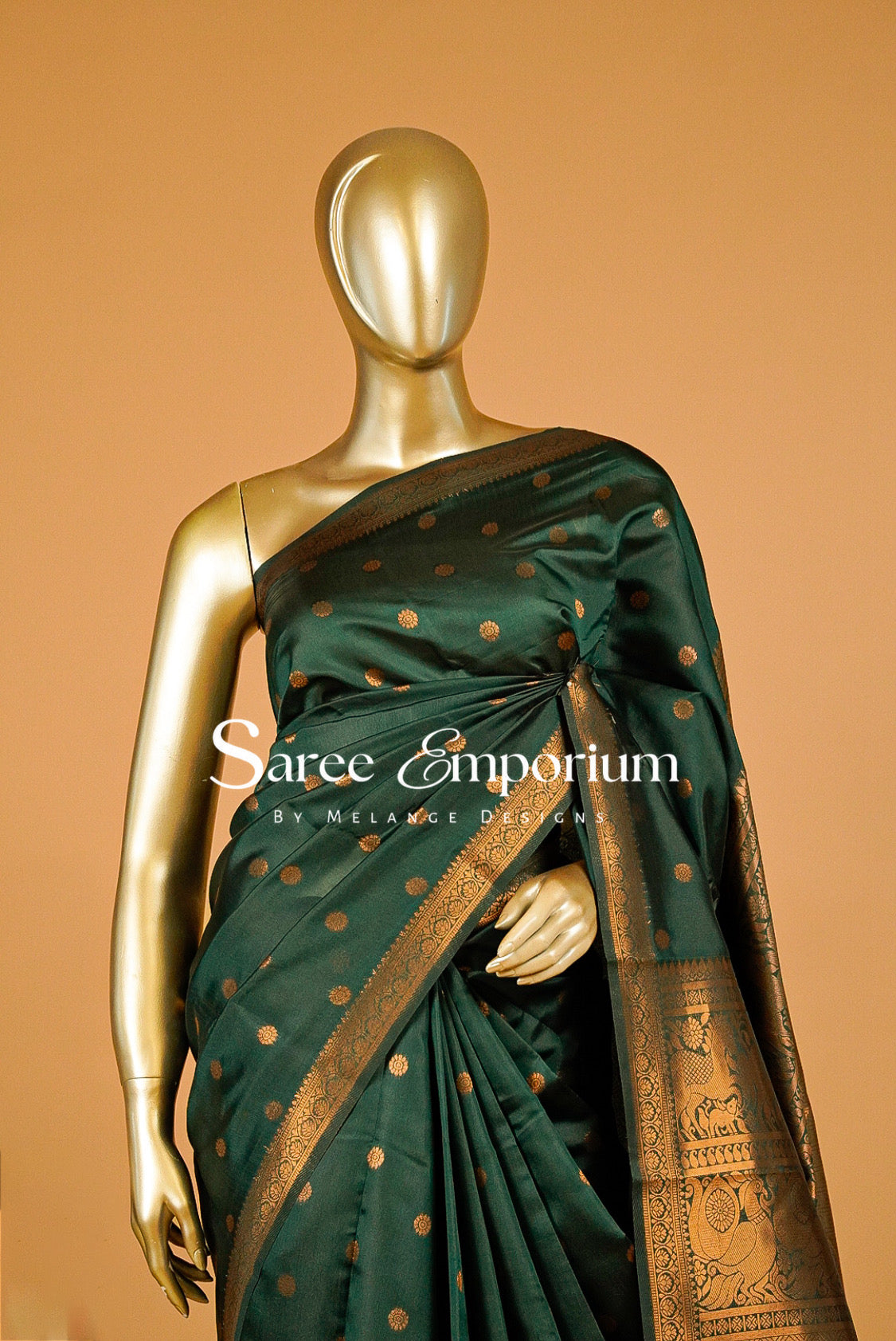 A dark green silk saree with gold zari motifs and borders.