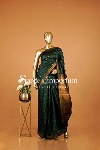 A dark green silk saree with gold motifs and a gold border.