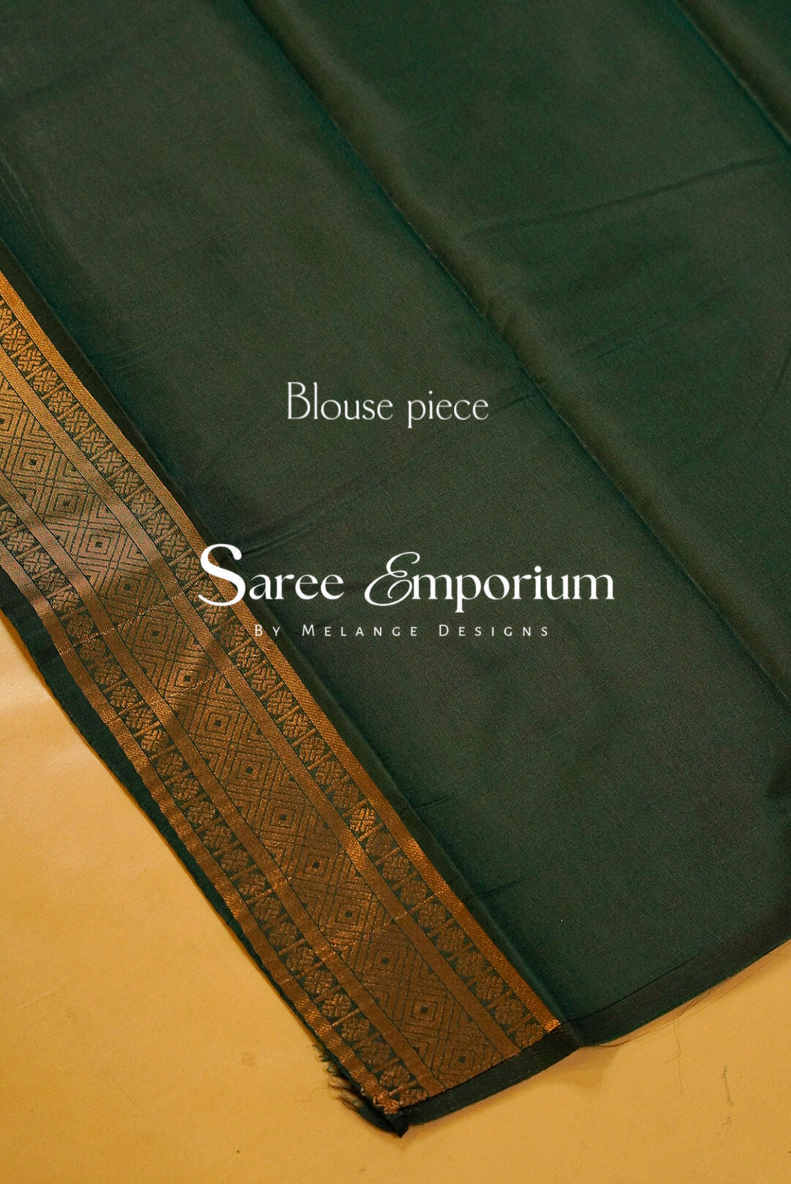 A dark green sari fabric with a wide gold and black patterned border.