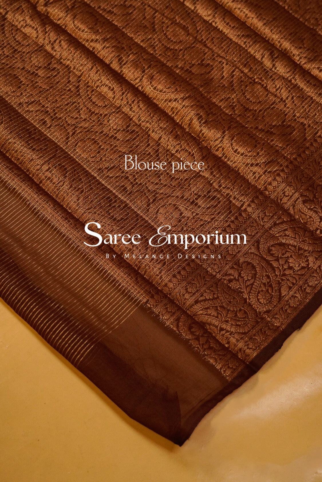 A close-up of a rust patterned fabric with a textured jacquard design and a solid border.