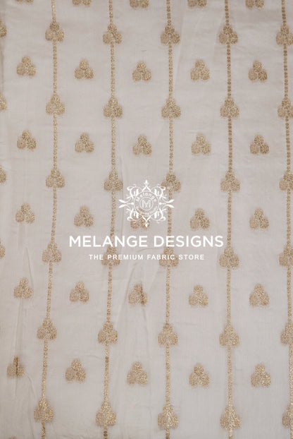 White organza Viscose Jaqured Dyeable Fabric with vertical gold sequin chains and small gold embroidered motifs.