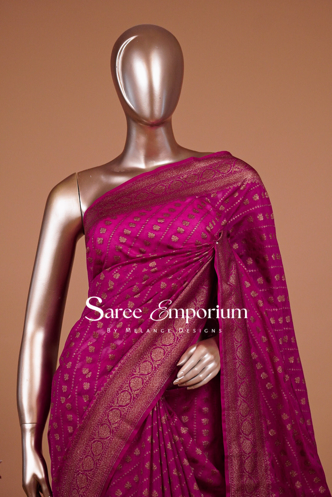 A metallic magenta pink saree with gold zari woven patterns .