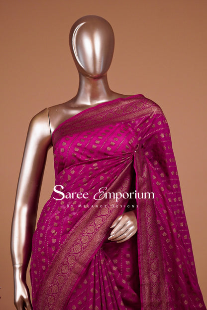 A metallic magenta pink saree with gold zari woven patterns .