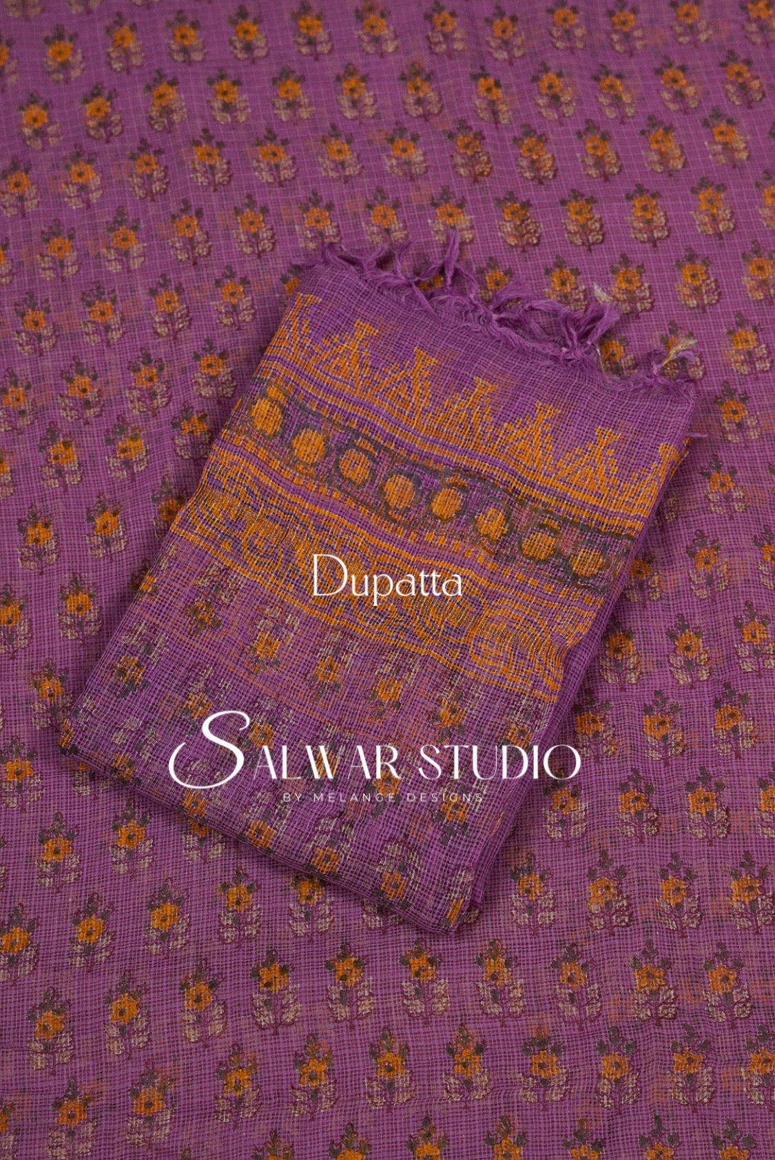 A folded purple dupatta with orange and yellow floral block prints and a patterned border.