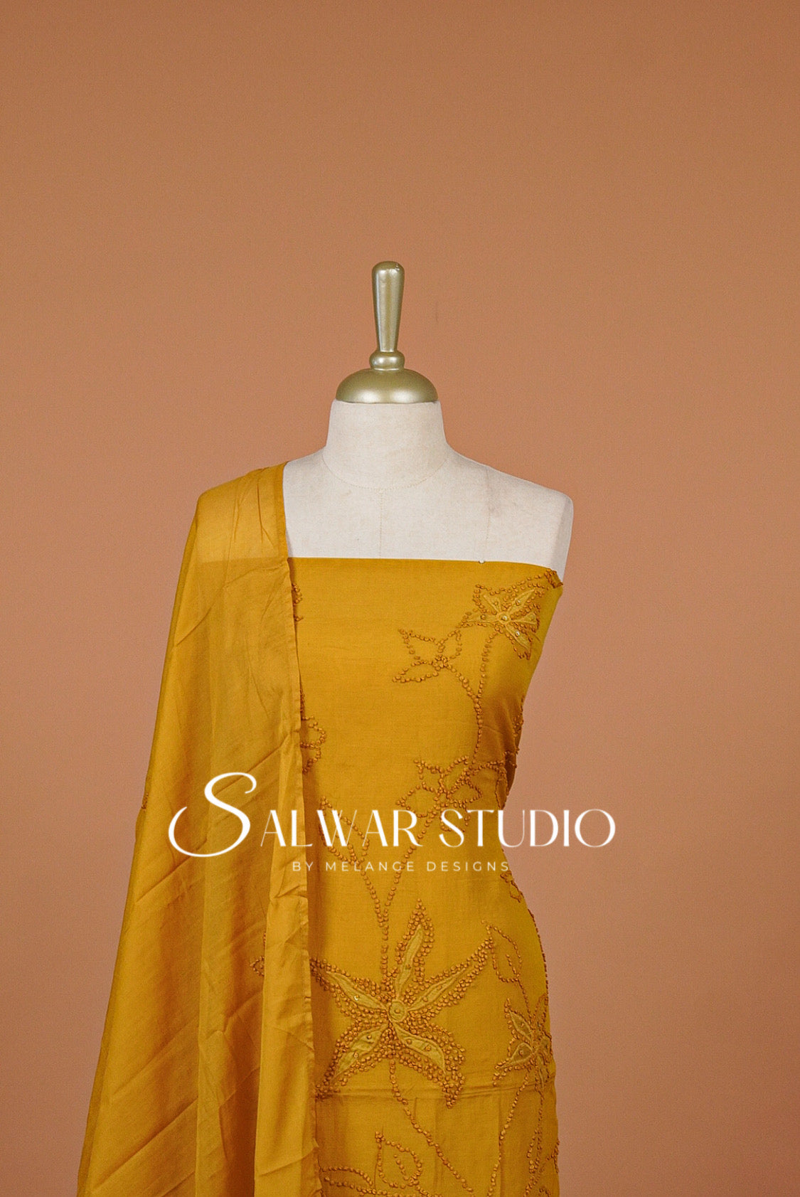 A mustard yellow embroidered salwar The salwar features detailed floral embroidery .