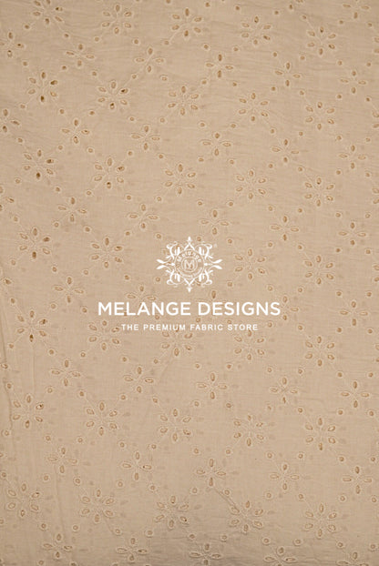 Beige eyelet Cotton Hacoba Fabric Dyeable with a repeating floral eyelet pattern.