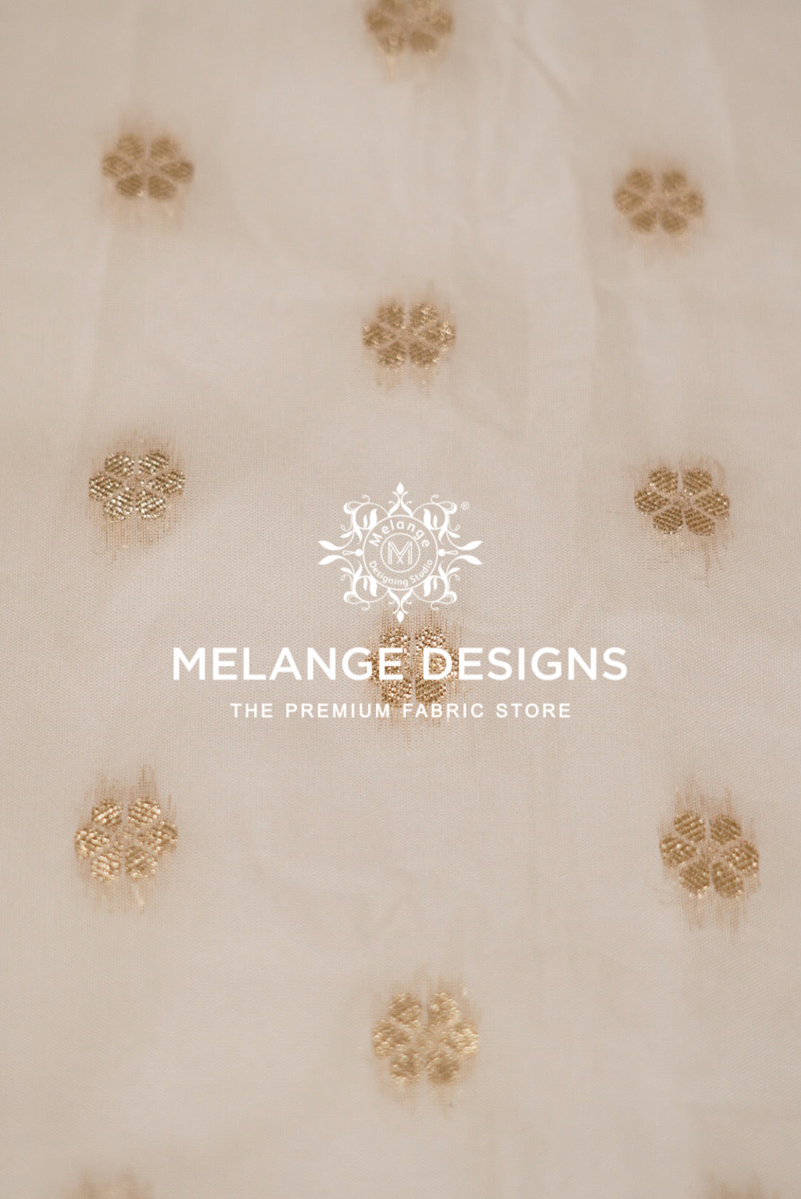 A close-up of a cream-colored Cotton Chanderi Brocade Dyeable  Fabric with scattered gold floral embroidery.