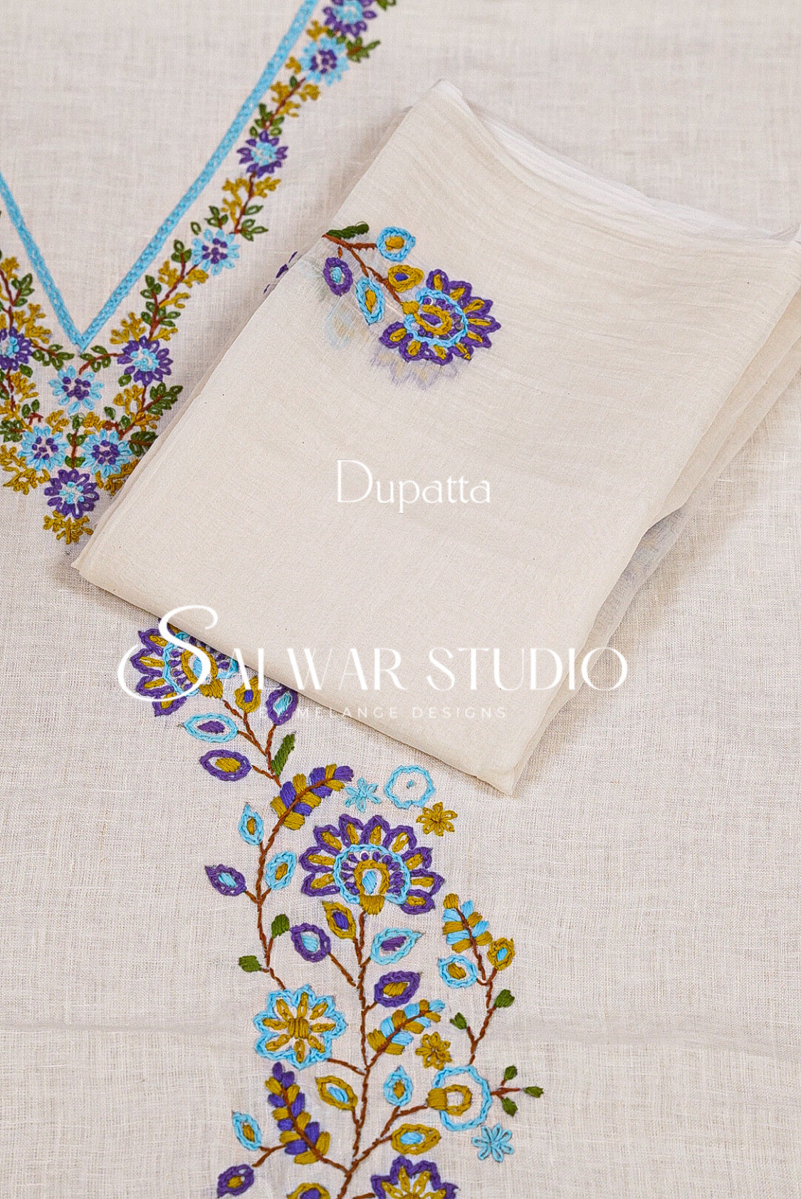 A folded off-white dupatta with colorful floral embroidery in blue, purple, yellow, and green.