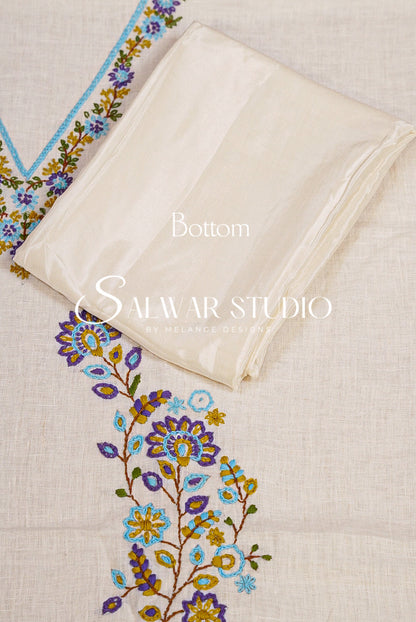 An off-white cotton fabric set with a floral embroidered neckline and a matching folded dupatta, featuring purple, blue, and yellow embroidery .