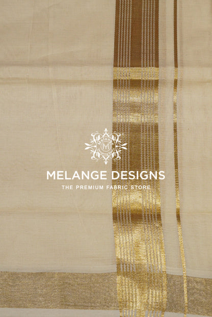 A close-up of a light beige or cream-colored fabric with a prominent metallic gold border and vertical stripes. 