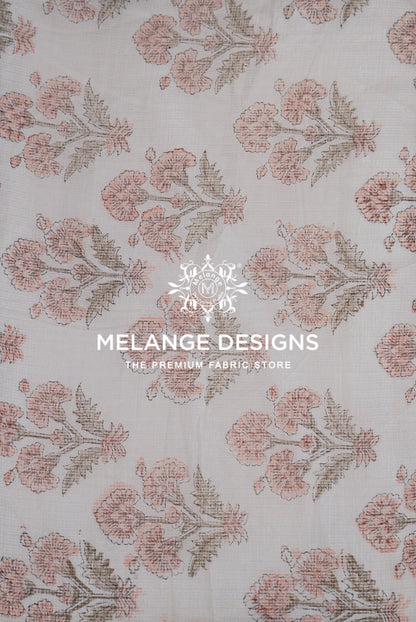 A close-up of a Printed Cotton Cotta Fabric pattern featuring a repeating floral design in dusty pink and muted brown .
