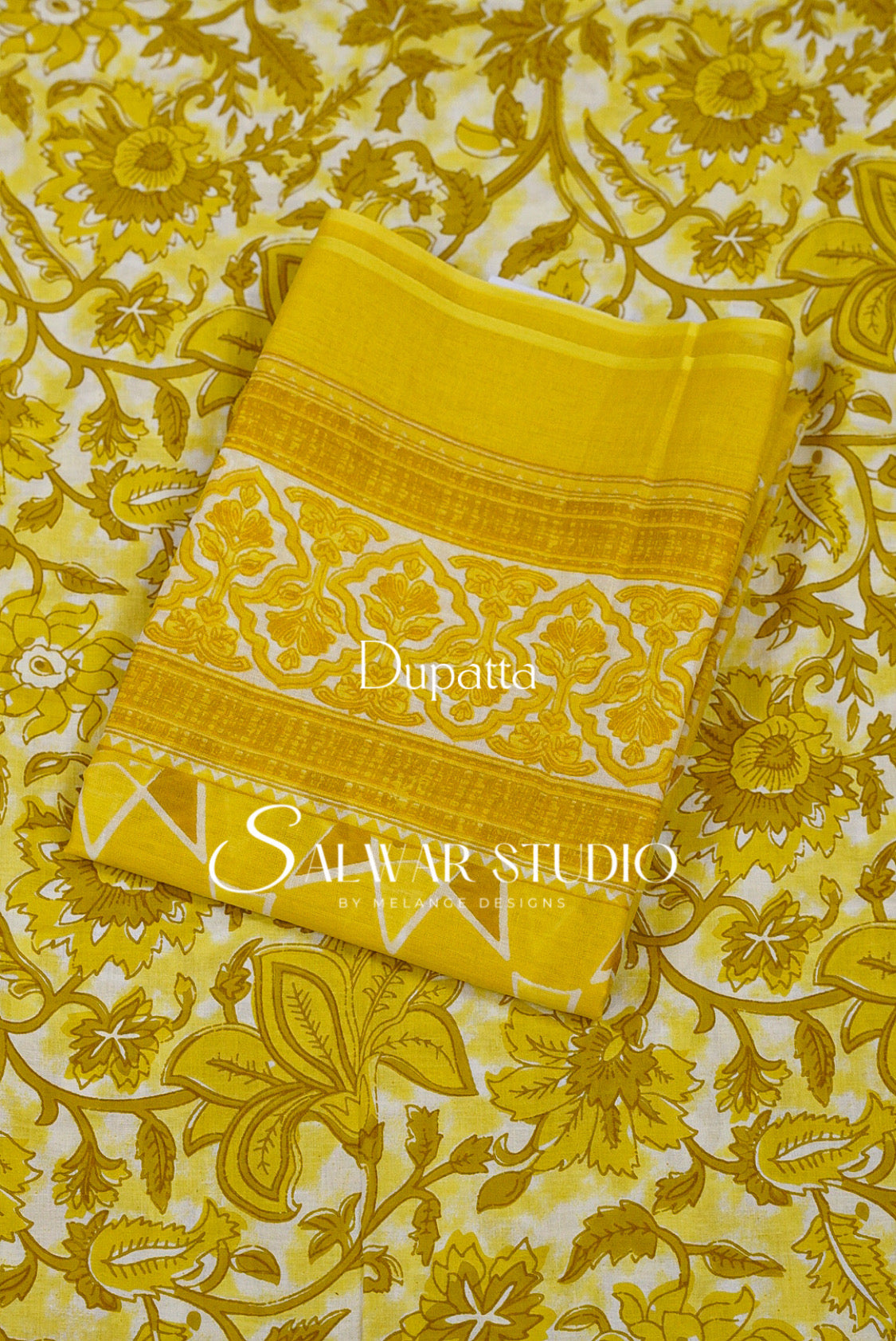 A folded yellow dupatta with a white floral pattern and gold borders.