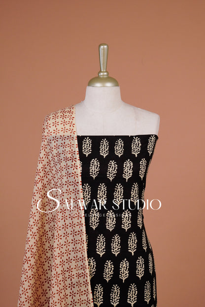 A mannequin torso displays a black fabric panel with beige leaf-like block prints and a peach dupatta.