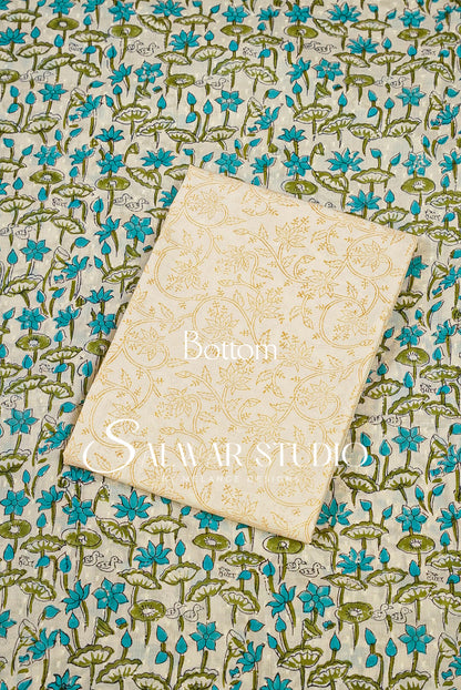 A cream-colored fabric bottom piece with a gold floral pattern, laid flat on top of a matching blue and green floral printed fabric. 