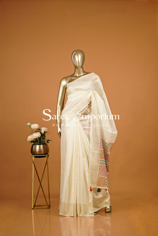 An off-white/cream saree draped .