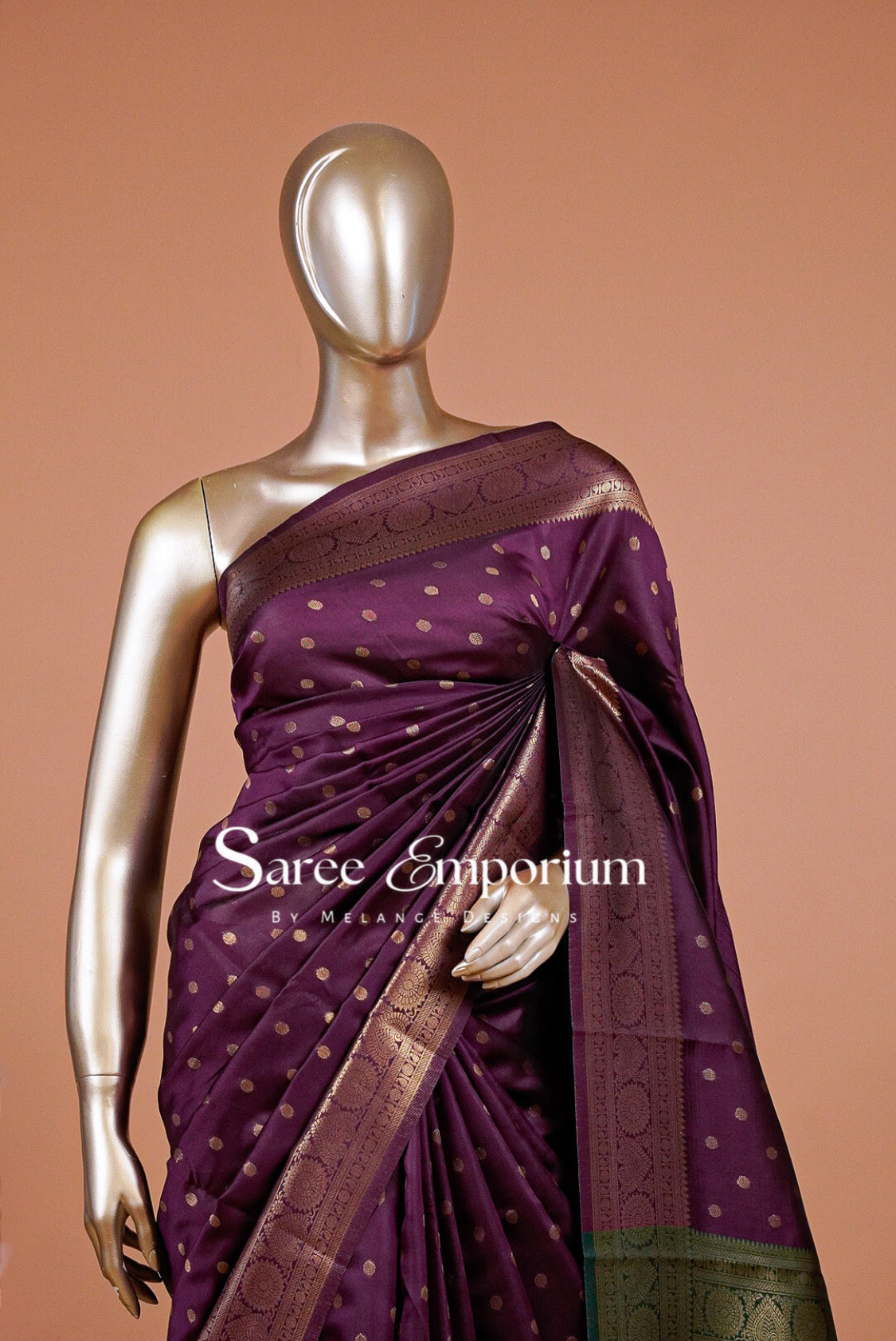A purple silk saree with gold motifs and a bronze border.